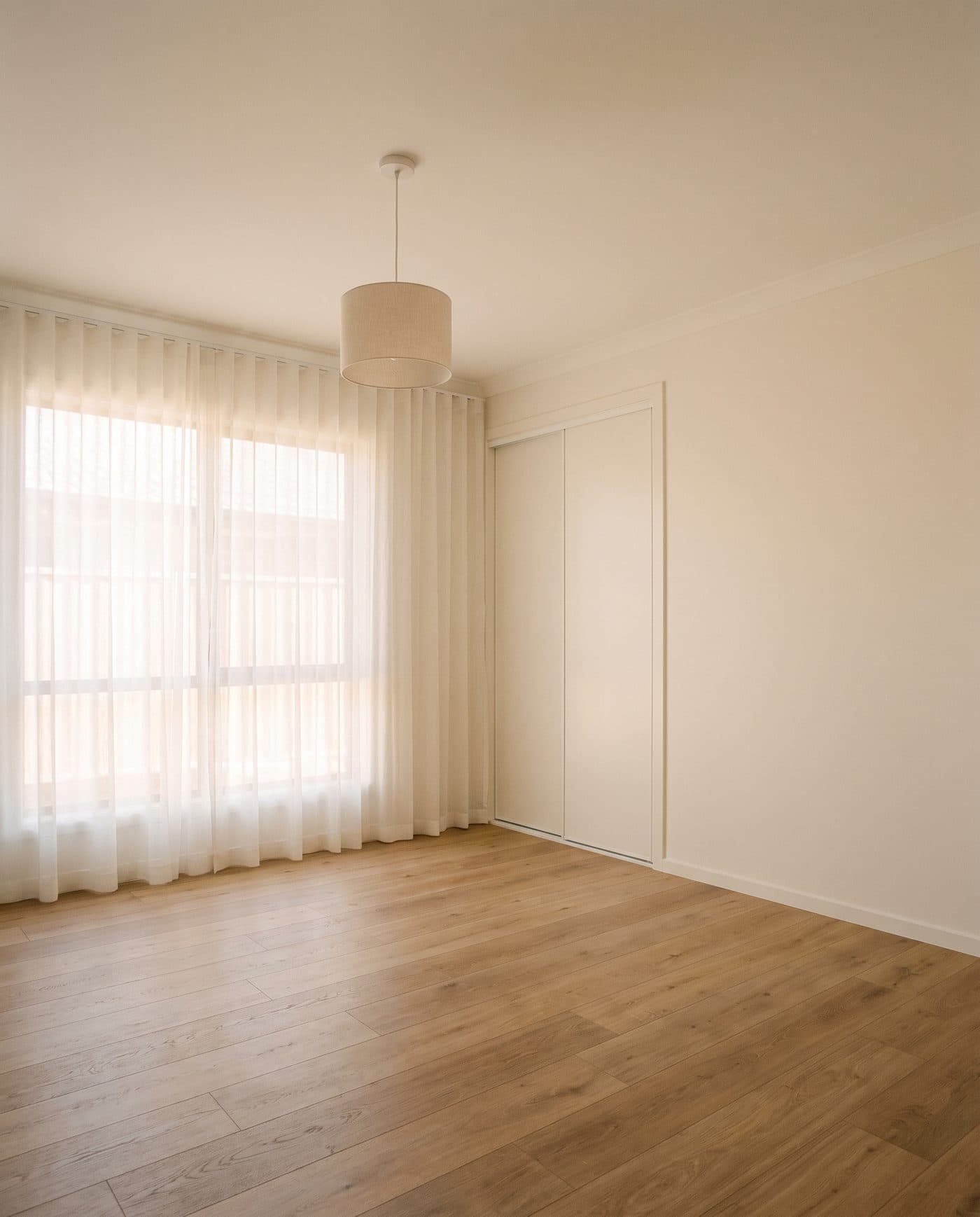 A dining table in an empty room, late light across the timber